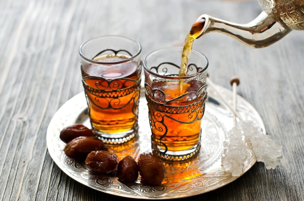 Ornate glasses of tea, dates, and sugar.