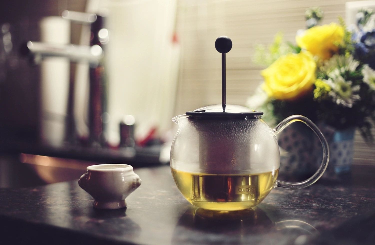 Glass teapot with tea and a cup.