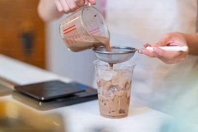 A woman poring a drink to a glass