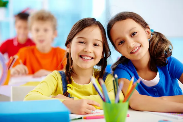 two kids sitting together on a table