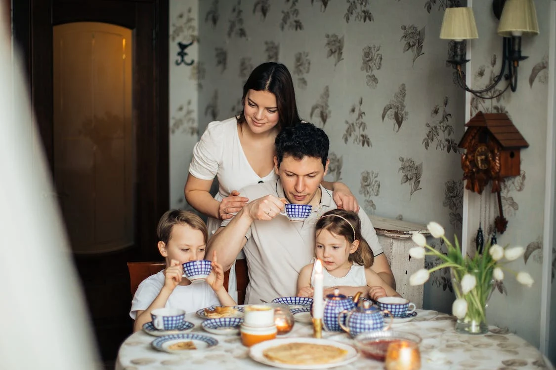 Family enjoys tea and snacks together.