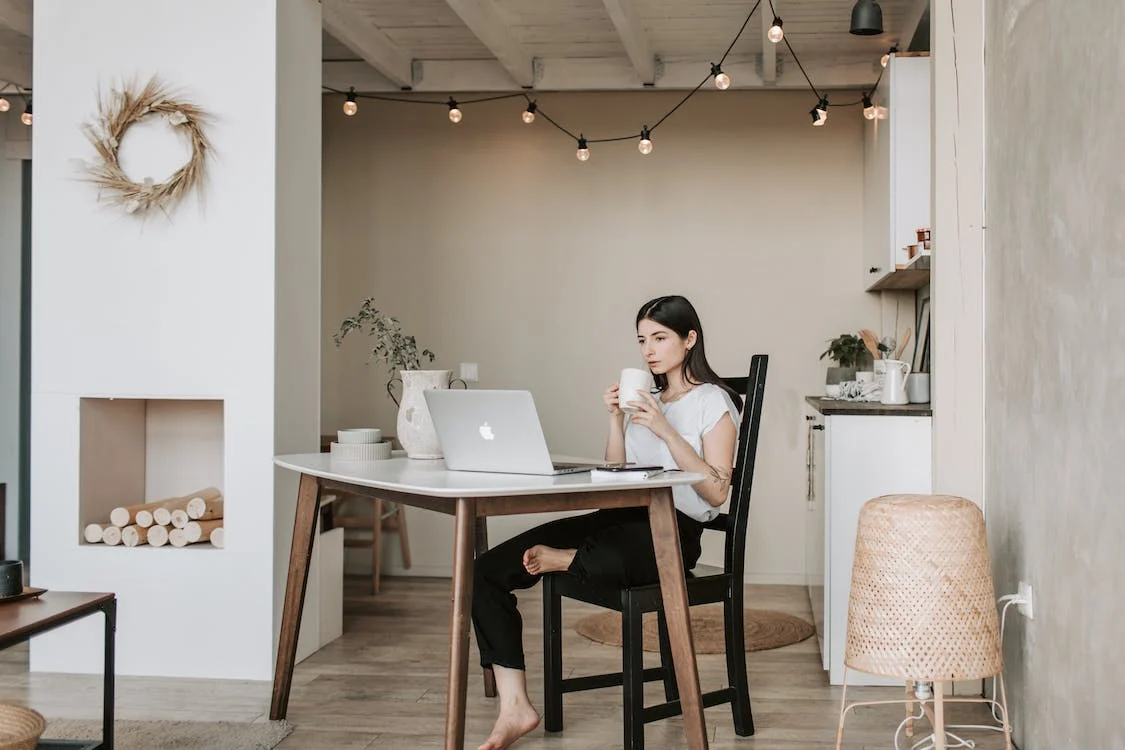 Woman working at a laptop in a home.