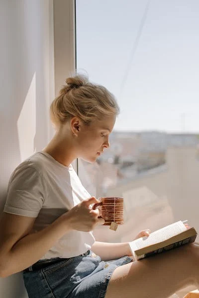 A woman having coffee and reading a book