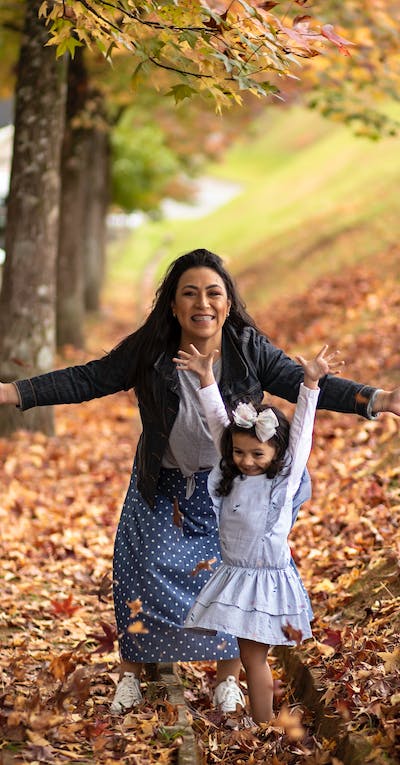 A woman and her child posing with trees around