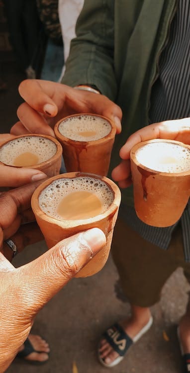 Three people holding cups of tea.