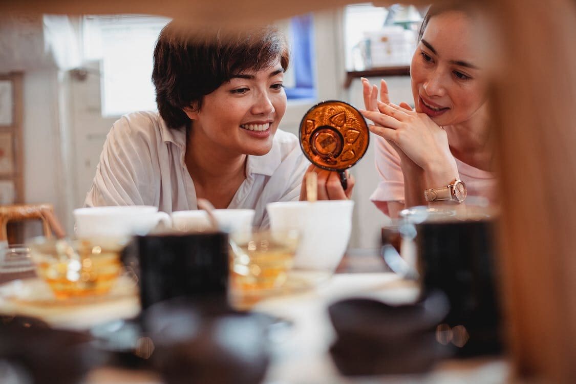 Two woman looking at an artifact or a cup