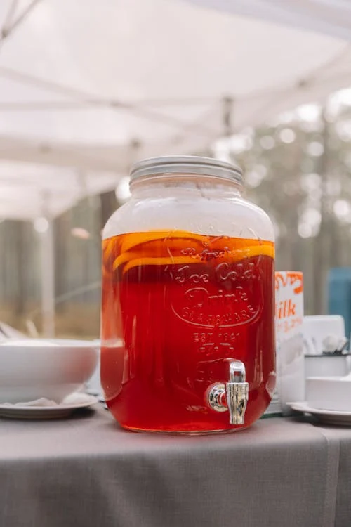 Glass pitcher of red fruit punch.