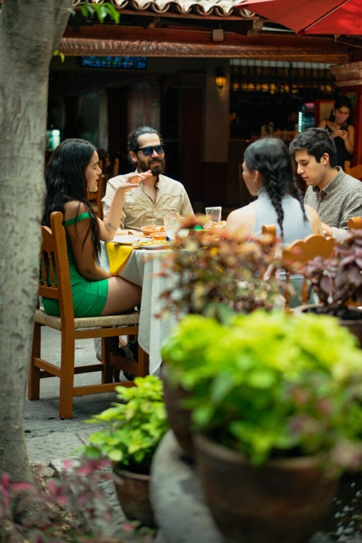 Four people dining outdoors at a restaurant.